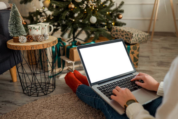 istock Young woman work on laptop computer with blank display screen with mockup copy space. Modern home living room interior design. Christmas, New Year decorated workspace 1804401346
