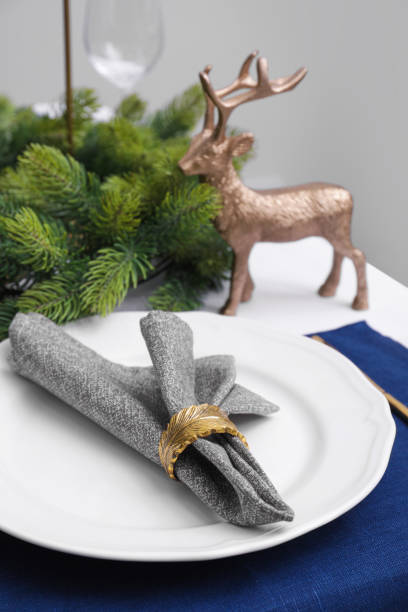 istock Festive place setting with beautiful dishware and fabric napkin for Christmas dinner on white table 1804407757