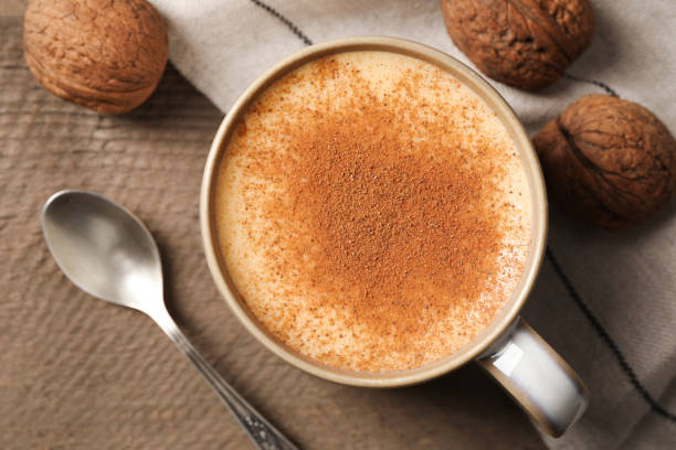 istock Delicious eggnog with cinnamon and walnuts on wooden table, flat lay. Space for text 1804409402