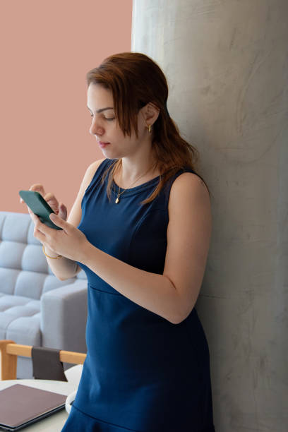 istock Woman using cell phone with sofa in the background 1804411085