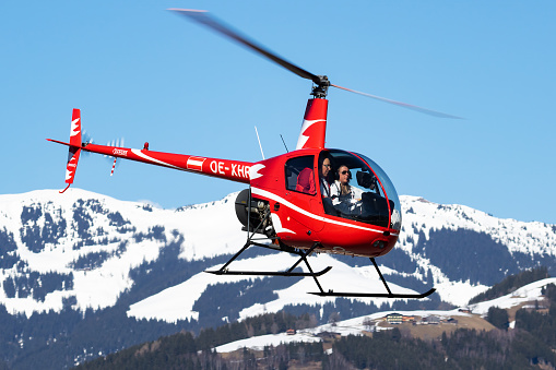 Zell am See, Austria - March 25, 2018: Commercial helicopter at airport and airfield. Rotorcraft. General aviation industry. Civil utility transportation. Air transport. Fly and flying.