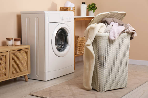 istock Laundry basket overfilled with clothes near washing machine in bathroom 1804453601