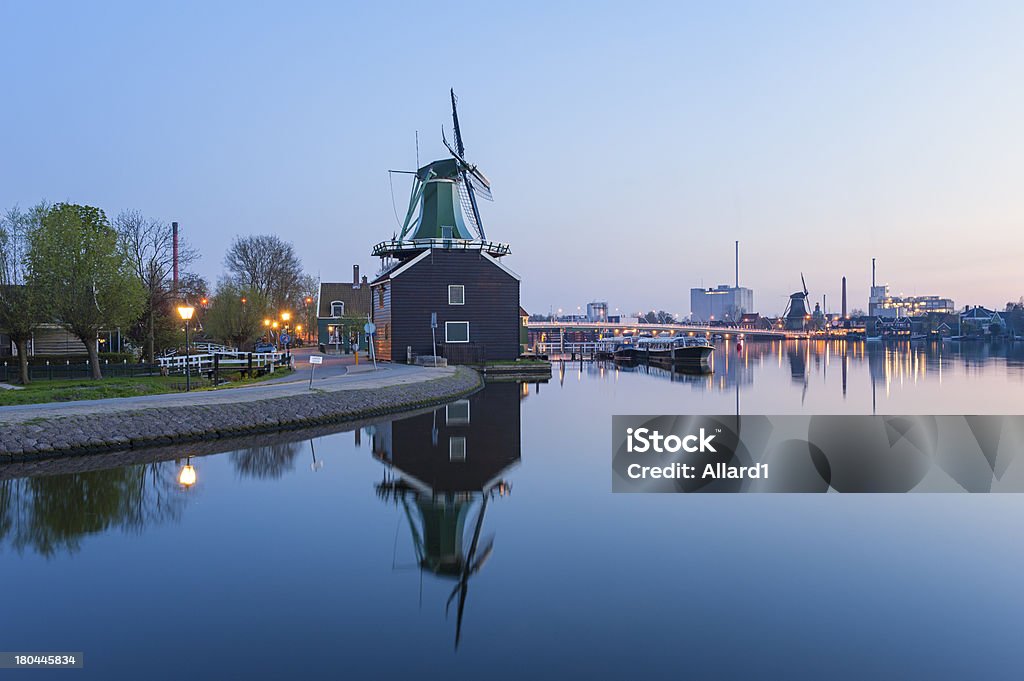 Zaanse Schans Windmill at sunset Windmill at Zaanse Schans, an industrial and national Dutch heritage site and popular tourist destination in the municipality of Zaandam, Netherlands. Captured at sunset. Factories and industry in the background. Architecture Stock Photo