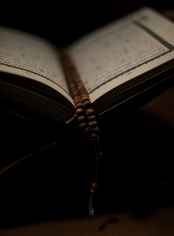 pages of holy koran and prayer beads at the book
