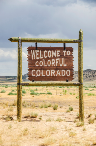 Brown and white sign to welcome travelers to colorful Colorado