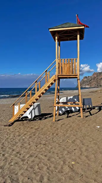 Photo of Lifeguard tower on the beach in the fall. Blue sky and clouds. Gazipasa castle.