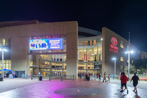 Houston, USA - October 20, 2023: nightview of downtown Toyota center in Houston. People hurry to entrance to join the performance.
