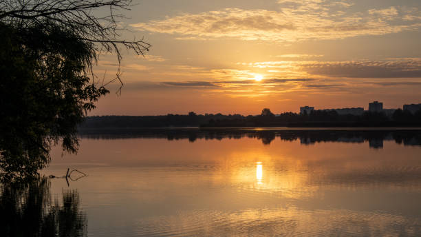 istock Sunrise sun on cloudy sky reflecting in lake water 1804499925