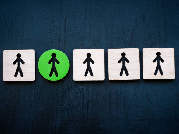 istock Wooden figures and one green one. Be different, be unique. 1804510092