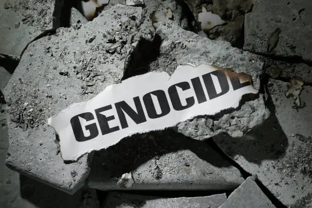 Paper with word Genocide on pieces of concrete, top view