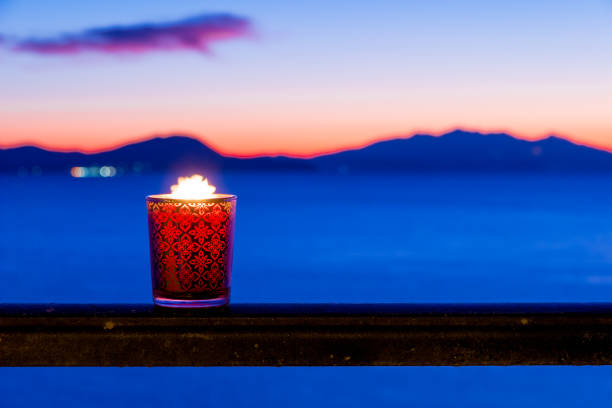 Candle glass at sunset in italy, sea and Elba island, in the background stock photo