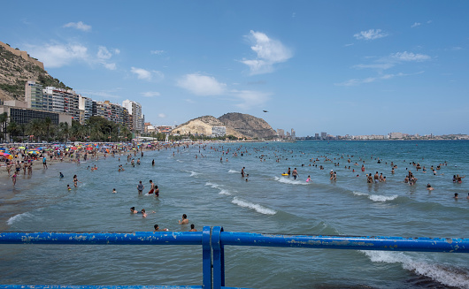 Plage De La Croisette Mediterranean Sea Beach Promenade In Cannes French Riviera France Europe, Building Exterior, Blue Sky, People Playing, Sunbathing, Swimming, Laying Down, Walking, Talking To One Another, Sitting Down During Springtime