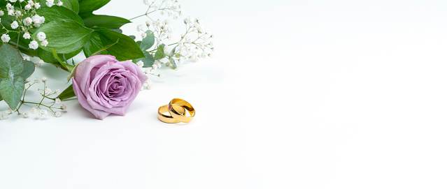wedding rings with rose on white background