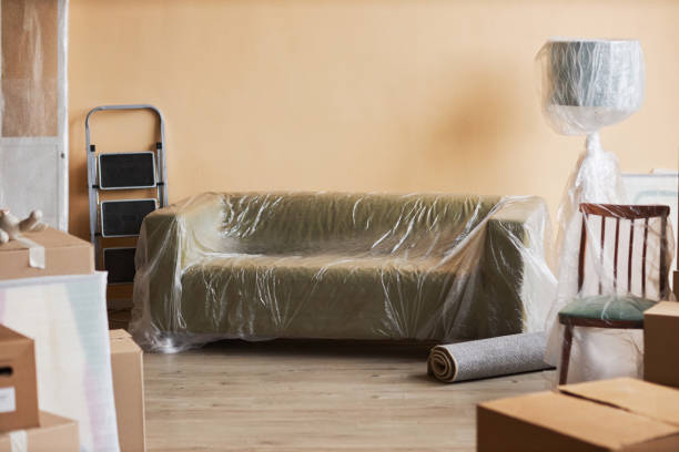 istock Long comfortable soft couch covered with cellophane standing by wall 1804551591