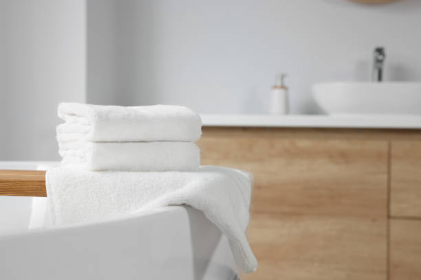 istock Fresh white towels on tub in bathroom. Space for text 1804556484