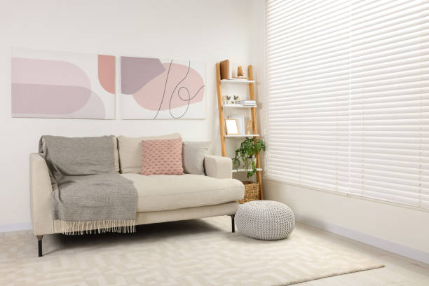 istock Stylish room interior with comfortable sofa, wooden shelf and pillows 1804557570