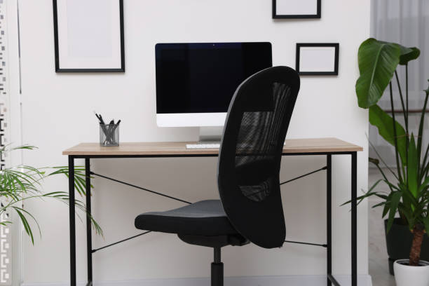istock Comfortable office chair near desk in modern workplace 1804557571