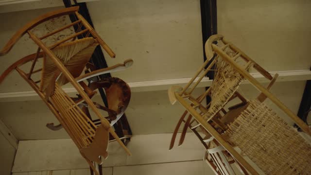 Woodworking Rocking Chairs hanging from ceiling of carpenter shop to dry finish