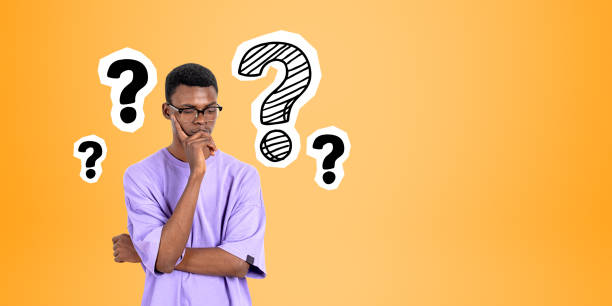 istock Pensive African man college student and question marks 1804571000