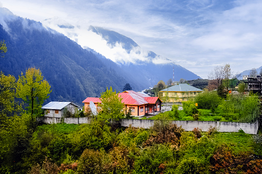 Amazing early morning view of a small colorful village below the mountain and cloudy sky at Sikkim, India