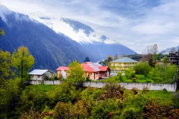 Amazing early morning view of a small colorful village below the mountain and cloudy sky at Sikkim, India