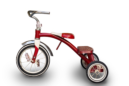 A vibrant red tricycle is photographed in a neutral white background