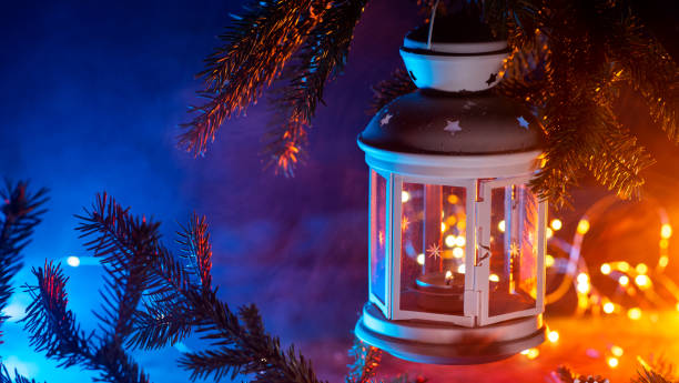 istock Christmas lantern hanging on a Christmas tree branch on a blue background 1804619430