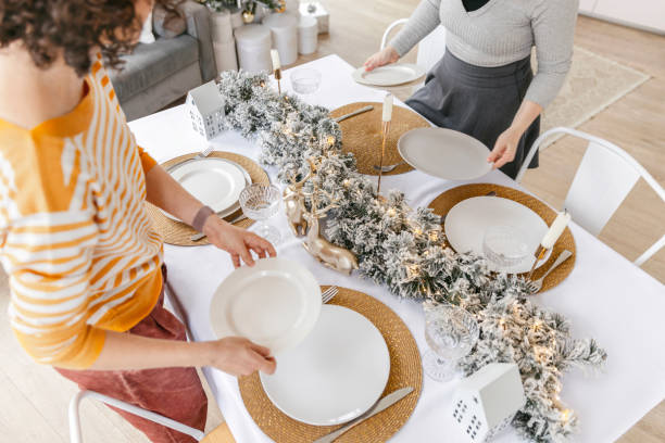 istock Women arranging dining table with christmas decoration 1804620000