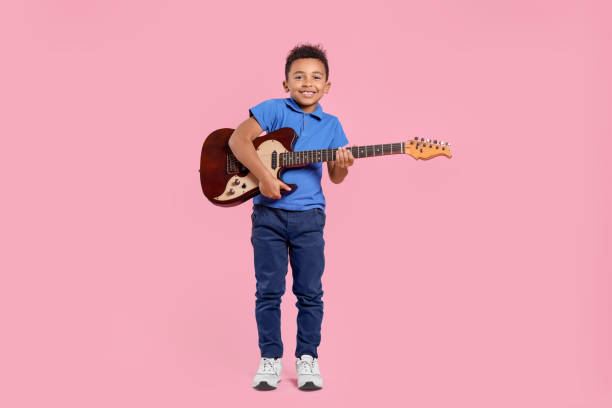 istock African-American boy with electric guitar on pink background 1804621134