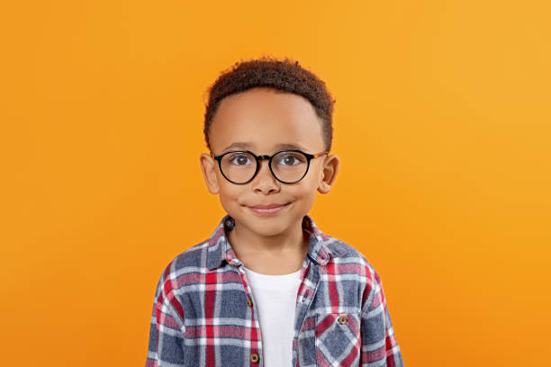 istock Cute African-American boy with glasses on orange background 1804621156