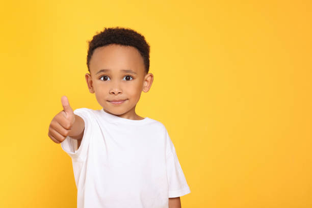 istock African-American boy showing thumb up on yellow background. Space for text 1804623864