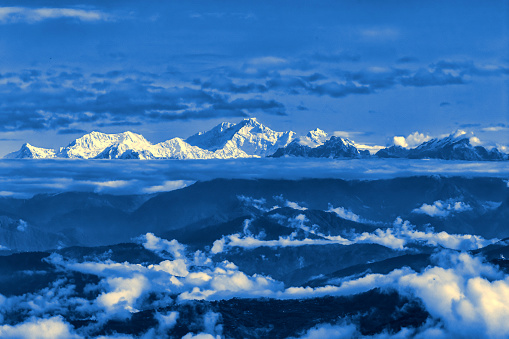Beautiful view from the mountain. Panorama. Mountain range with visible silhouettes through the morning blue fog