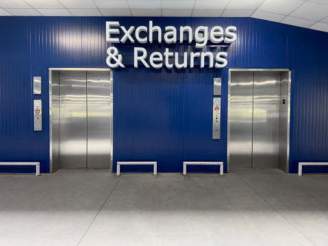Elevator in an industrial building  with exchanges and returns sign