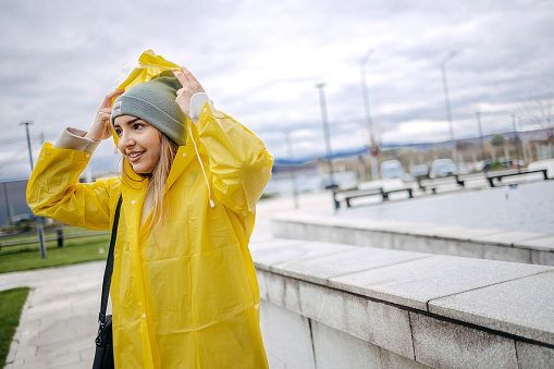 Young woman on her way to work outside on rainy day