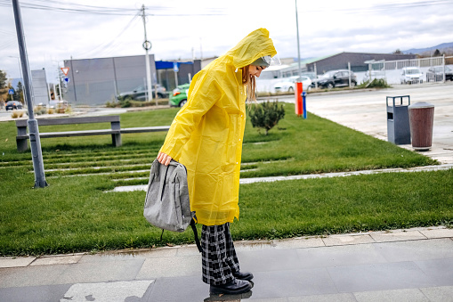 Young woman on her way to work outside on rainy day