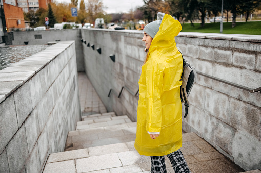 Young woman on her way to work outside on rainy day