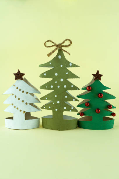 istock Handmade Christmas trees made from cardboard on yellow background 1804674380