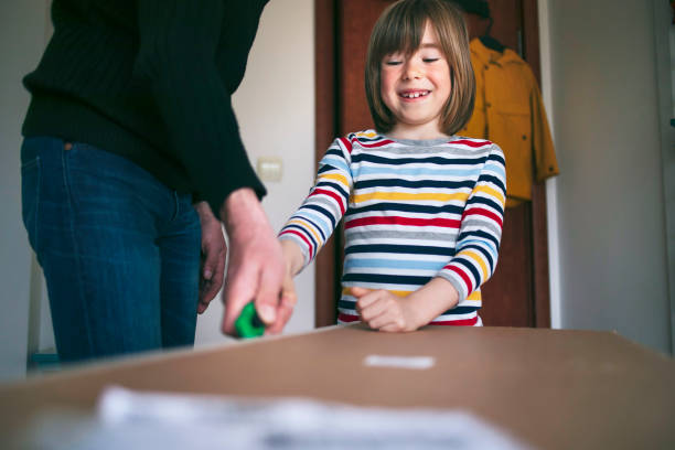istock Father and son opening delivery box at home 1804678045