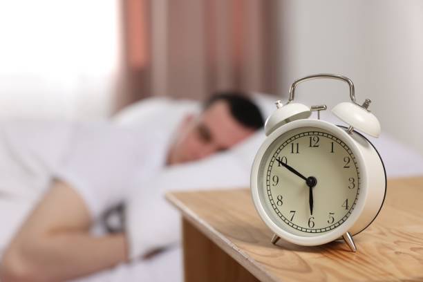 istock Man sleeping in bedroom, focus on alarm clock. Space for text 1804678068