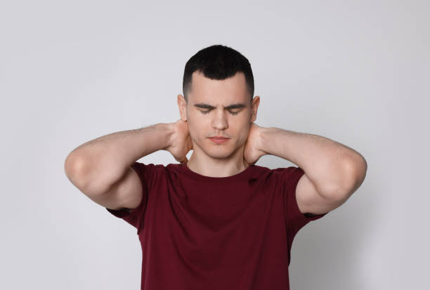 istock Man suffering from pain in his neck on light background. Arthritis symptoms 1804680746