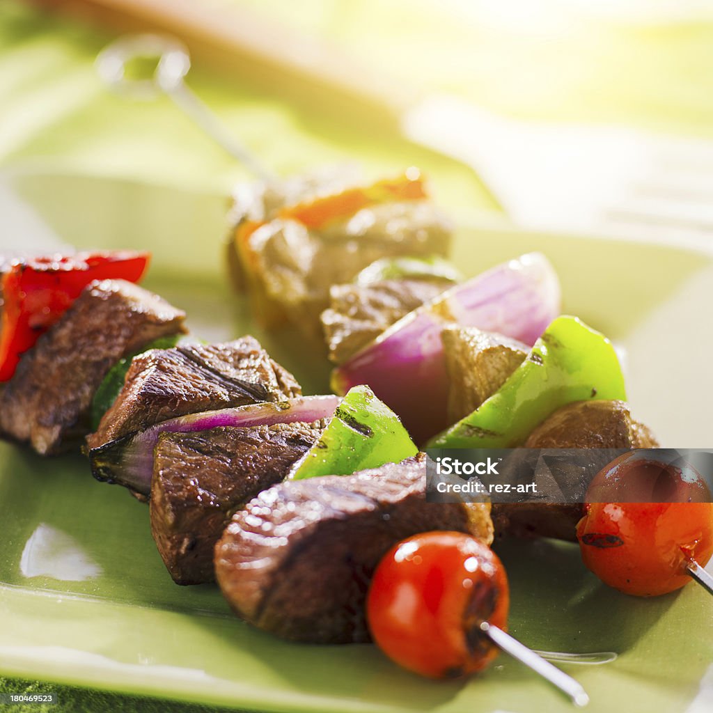 shishkabobs di manzo alla griglia su un piatto verde - Foto stock royalty-free di Alla brace
