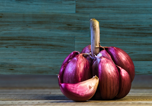Garlic Cloves and Bulb on the wooden table and blue green wood background in Brazil. Copy space.
