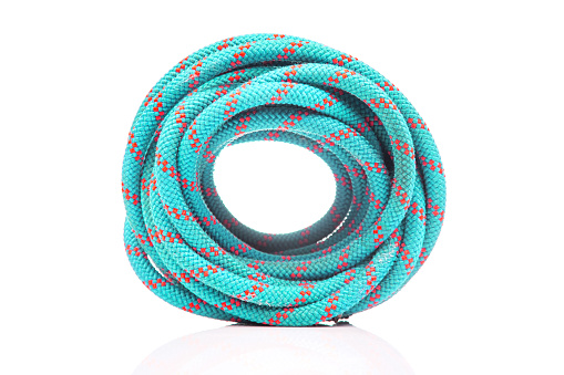 durable colored rope for climbing equipment on a white background. climbing rope. coil of braided cable. item for tourism and travel
