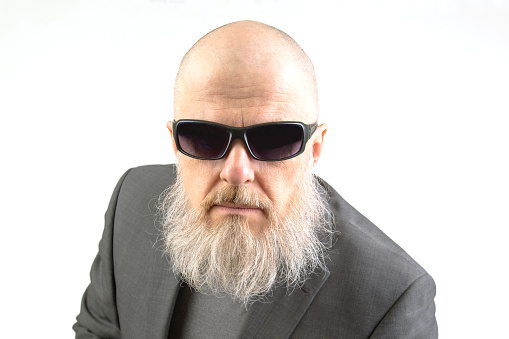 Bald bearded man in sunglasses on white background