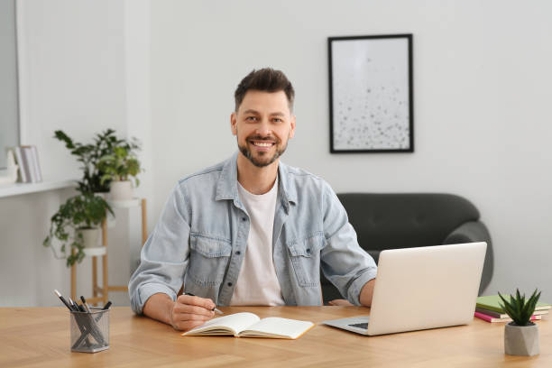 istock Man studying on laptop at home. Online translation course 1804716782