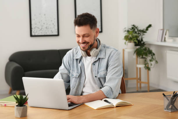 istock Online translation course. Man typing on laptop at home 1804717350