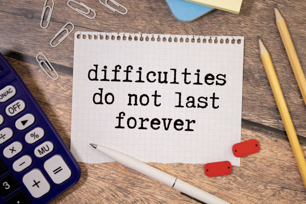 istock difficulties do not last forever. text on paper. text on notepad on white background. near the wooden cubes 1804724223