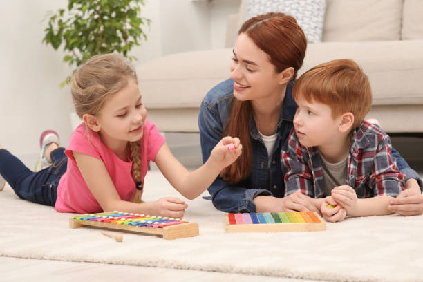 istock Happy mother and children playing with different math game kits on floor in room. Study mathematics with pleasure 1804741928