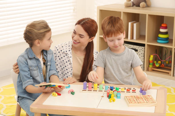 istock Happy mother and children playing with different math game kits at desk in room. Study mathematics with pleasure 1804741959