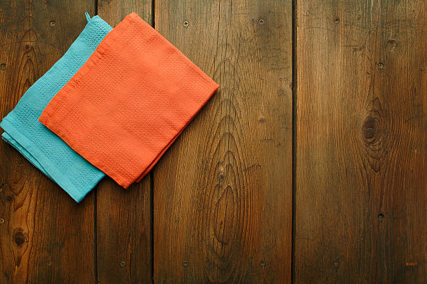 istock Wooden kitchen table with two folded dishcloths on 180474407